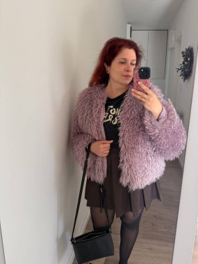 Kendine güvenen bir kadın şık bir koridorda selfie çekiyor. İfade, özalgı ve bireysellik modern moda ve kentsel yaşam tarzında