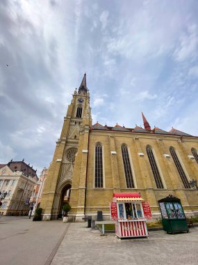 13 Ağustos 2022, Novi Sad, Sırbistan: Novi Sad 'daki Katedral ve bulutlu gökyüzü altında parlak bir kule. Kentsel çevrede inanç, mimari, miras ve ruhani varlık