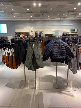 Modern çocuklar dış giyim, pantolon ve kazak raflarıyla doğal ve dünyevi tonlarda perakende satıyorlar. Mevsimlik moda, alışveriş atmosferi ve ticari perakende tasarımı