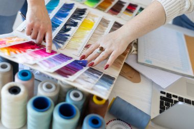Yaratıcı çalışma alanındaki kumaş rengi palet örneklerini analiz eden tasarımcı takımı. Moda tasarımı, işbirliği ve takım çalışması