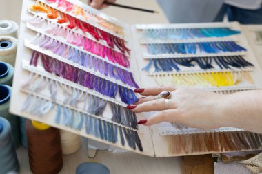 Moda tasarımcısı, kumaş rengi örnekleri ve numuneleri stüdyoda düzenliyor. İlham, tasarım geliştirme ve tekstil işçiliği