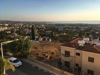 Sabah sıcağı Paphos 'un çatılarını aydınlatıyor. Huzurlu şehir hayatı, Akdeniz sakinliği ve sakin sahil atmosferi.