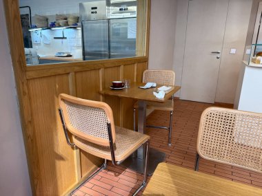 Boş bir bardakla karışık bir kafe köşesi ve ahşap bir masada kullanılmış peçeteler. Günlük gerçeklik, hayatın izleri ve insan varlığının sessiz sonuçları.