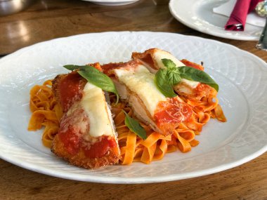 Domates soslu İtalyan makarnası, erimiş peynir ve fesleğen yaprağı. Güneşli bir öğleden sonra Akdeniz mutfağının konforlu yiyeceği, tadı ve sıcaklığı