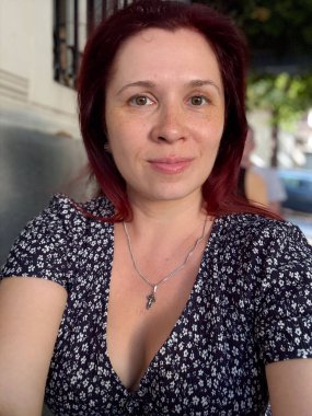 Açık kafede doğal ışık ve rahat bir yüz ifadesi olan kadın portresi. Güzellik, özgünlük ve günlük insan varlığının sıcaklığı.