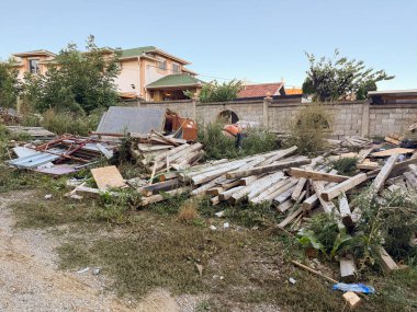Arka bahçedeki döşemeler ve aletler yıpranmış. İnşaat süreci, kentsel bozulma ve atık maddelerin çevresel etkileri