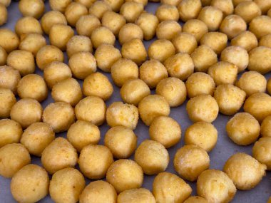 Kağıt üzerinde küçük kızarmış patates topları yakın plan. Ev yapımı aperatif, yemek dokusu ve basit mutfak kompozisyonu.