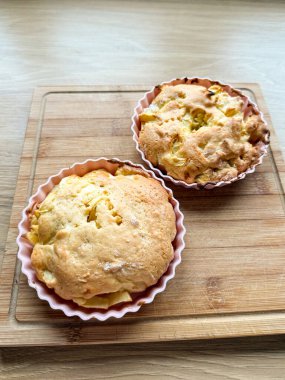 Tahtadaki silikon kalıplarda ev yapımı elmalı kekler. Pasta hazırlama, tatlı pişirme ve evde basit bir tatlı tarifi.