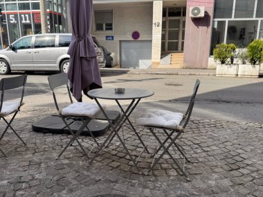 Açık kafe masası ve kaldırım taşı sokağındaki sandalyeler. Kentsel eğlence, Avrupa atmosferi ve şehir yaşam tarzında sosyal rahatlama