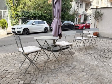 Açık kafe masası ve kaldırım taşı sokağındaki sandalyeler. Kentsel eğlence, Avrupa atmosferi ve şehir yaşam tarzında sosyal rahatlama