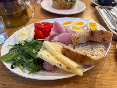 Yumurta, ekmek, jambon, peynir ve sebzeli sağlıklı bir kahvaltı. Dengeli sabah beslenmesi, taze malzemeler ve ev yapımı yemek ilhamı.