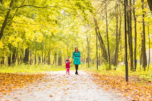 Mutlu anne ile kızı sonbahar Parkta yürümek için — Stok fotoğraf