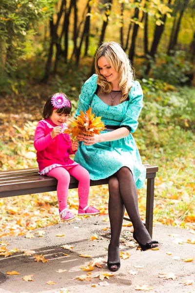 Glad mamma med sin dotter en promenad i höst park — Stockfoto