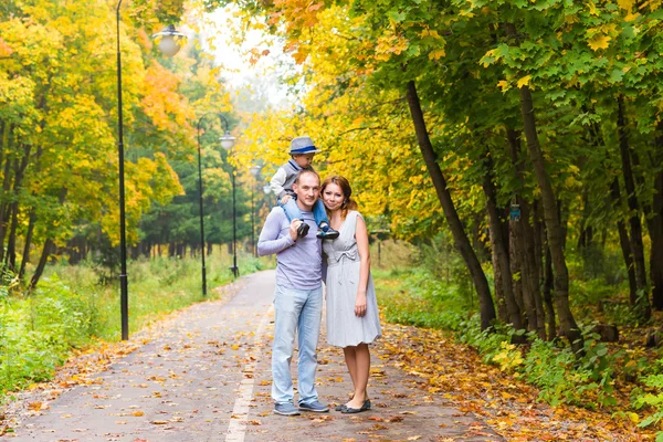 Ung familj för en promenad i parken hösten med baby — Stockfoto