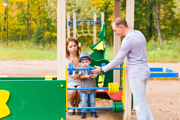 Familia joven para dar un paseo en el parque de otoño con el bebé — Foto de Stock