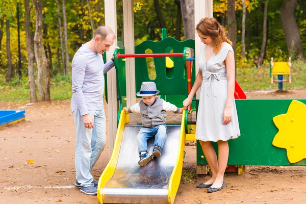 Ung familj för en promenad i parken hösten med baby — Stockfoto