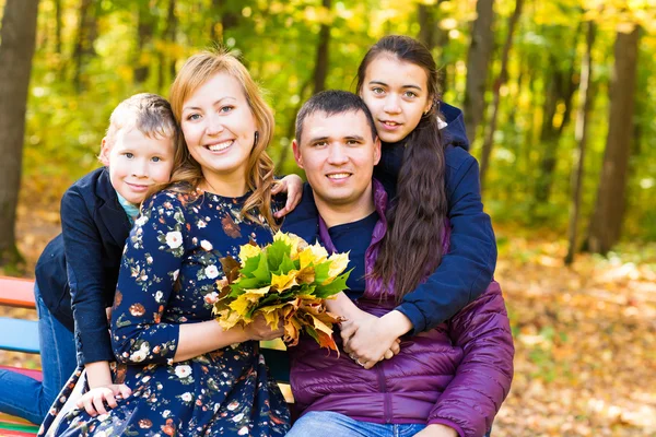 Família bonito em um parque em um outono — Fotografia de Stock