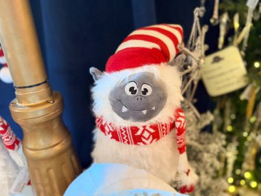 Bayram renklerinde giyinmiş neşeli, pelüş yeti. Neşeli kış hikayeleri, neşeli cazibe ve sıcak festival atmosferi tuhaf mevsimsel kutlamalar ve dekoratif fantezi havası yaratıyor..