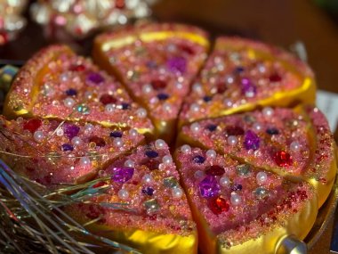 Noel süsleri pırıltılı pizza dilimleri mücevher ve boncuklarla kaplı Noel süsü olarak. Kutlama eğlencesi, yaratıcı tatil stili, kaprisli festival aksanları ve neşeli mevsimsel ışıltı