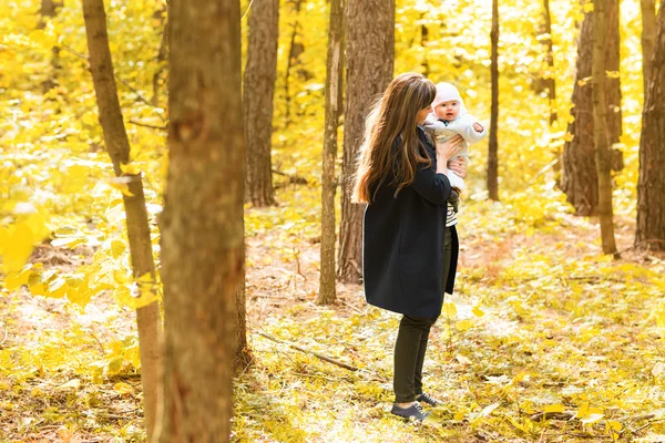 Счастливая молодая мать с маленькой дочкой в осеннем парке — стоковое фото