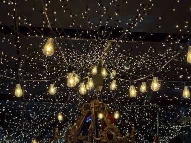 Ilık beyaz ampuller ve ayna yüzeyinde yansıyan peri ışıkları. Yumuşak kış kutlama havası, ışıl ışıl Noel atmosferi, büyülü tatil sahnesi ve aydınlatma tasarımı.