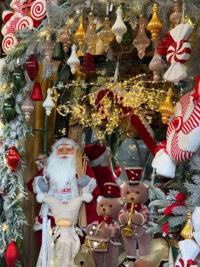 Noel Baba ve oyuncak ayı müzisyenleri süslü bir Noel dükkanının vitrininde. Sıcak bayram cazibesi, nostalji, çocukluk sevinci ve şenlikli kış kutlaması. Detaylı mevsimsel dekorlarla çekildi..