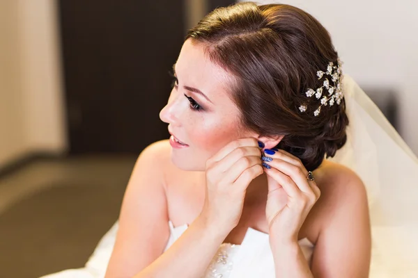 Hermosa novia joven con maquillaje de boda y peinado, mujer recién casada preparación final para la boda. Feliz novio de la novia esperando. Momento del día de boda . — Foto de Stock