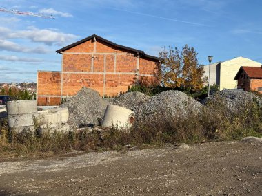 İnşaat ve inşaat malzemeleri dışarıda. Kentsel genişleme, gelişim ve tamamlanmamış mimari manzara