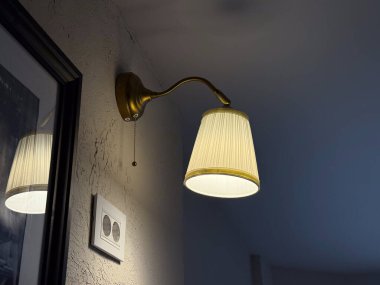 Kafe köşesinde parlayan bir lamba. İç aydınlatma, akşam atmosferi, dekor detayı ve sıcak gevşeme atmosferi..