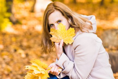 Sonbahar yapraklı genç bir kadın.