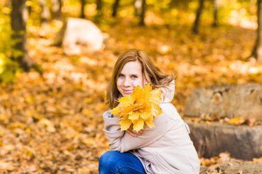 Sonbahar yapraklı genç bir kadın.
