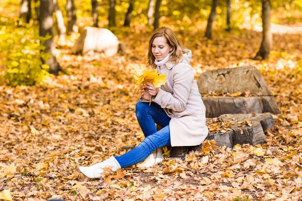 Pretty woman relaxing in the autumn park — Stock Photo, Image