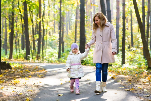 Anne ve kızı sonbahar parkta yürüyüş