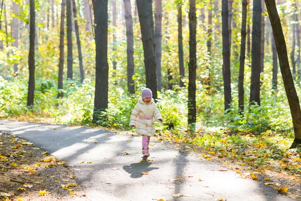 Menina criança feliz se divertindo no parque de outono . — Fotografia de Stock