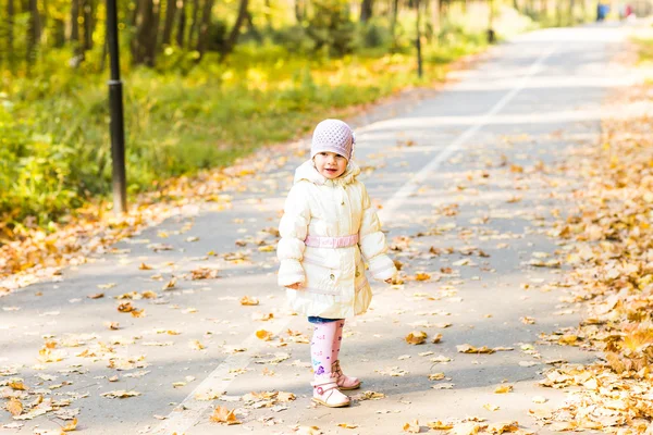 Menina criança feliz se divertindo no parque de outono . — Fotografia de Stock