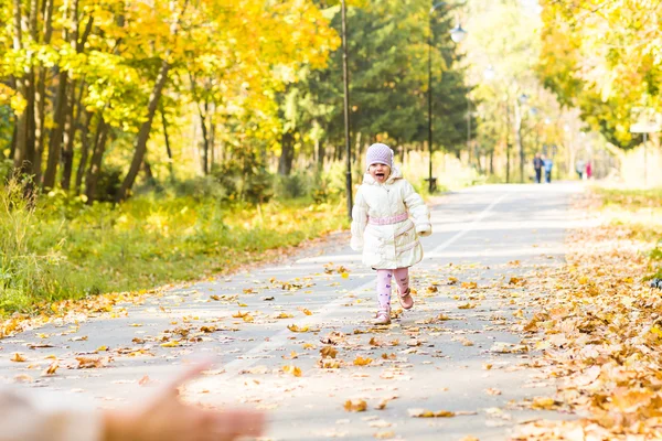 Menina criança feliz se divertindo no parque de outono . — Fotografia de Stock