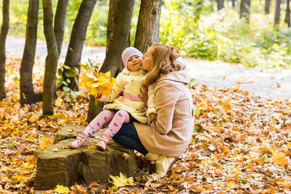 Mami, líbat její dcera v parku. Žena s dítětem na podzimní Les. — Stock fotografie