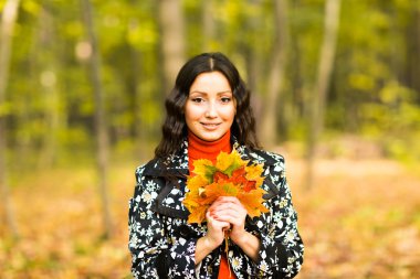 Sevimli kız tutan eller sarı akçaağaç yaprakları