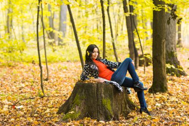 Genç bayan sonbahar parkında dinleniyor.