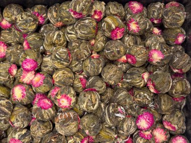 İstanbul pazarında pembe çiçeklerle süslenmiş el yapımı çay topları. Sanatsal işçilik, merasim birası, görsel zarafet ve heykeltraşlık yoluyla dikkatli çay kültürü.