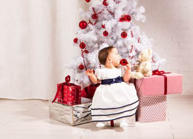 Noel ağacının altında oturan kız şirin bebek