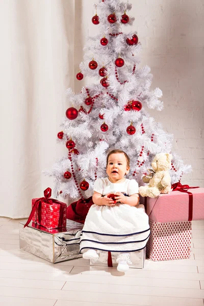 Концепція Нового року. Дитячий малюк, який сидить під прикрашеною ялинкою, готує подарунки для святкування — стокове фото