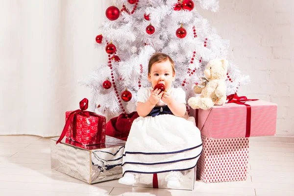 Conceito de ano novo. Criança bebê criança sentada sob árvore de natal decorada preparando presentes presentes para celebração — Fotografia de Stock