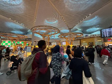 İstanbul havaalanı gümrük vergisiz koridorundan geçmekte olan yolcular, dükkanlar ve ışıklandırma tasarımı ile. Seyahat yaşam tarzı, perakende tüketimi, aile ulaşımı, uluslararası hareketlilik, ticari altyapı ve modern havaalanı deneyimi