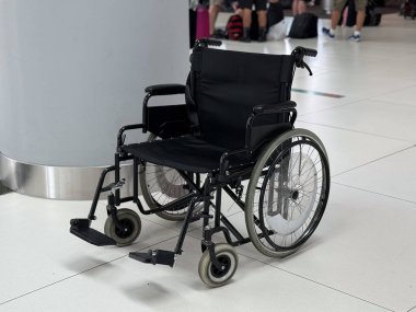 Havaalanı terminalindeki boş tekerlekli sandalyenin yan görüntüsü. Ayrıntılı ulaşım kavramı, ulaşılabilirlik yardımı erişilebilirlik bilinci ve yolcular için destek