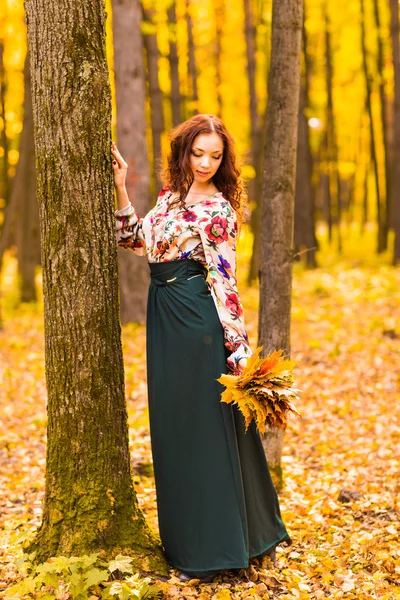 Jeune femme aux feuilles d'automne à la main — Photo