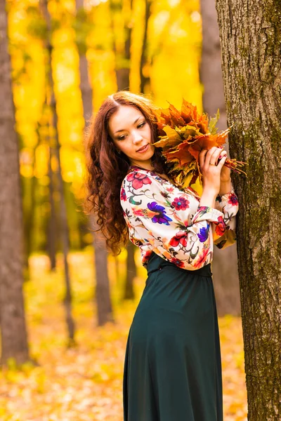 Schöne elegante Frau steht in einem herbstlichen Park — Stockfoto