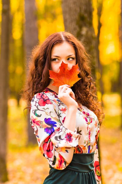 Jeune femme aux feuilles d'automne à la main — Photo