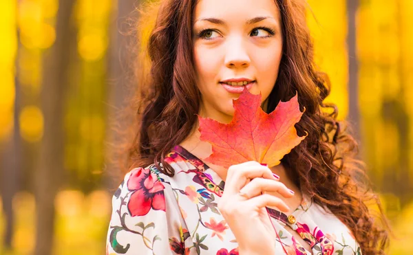 Jeune femme aux feuilles d'automne à la main — Photo