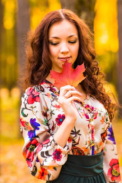 Jeune femme aux feuilles d'automne à la main — Photo